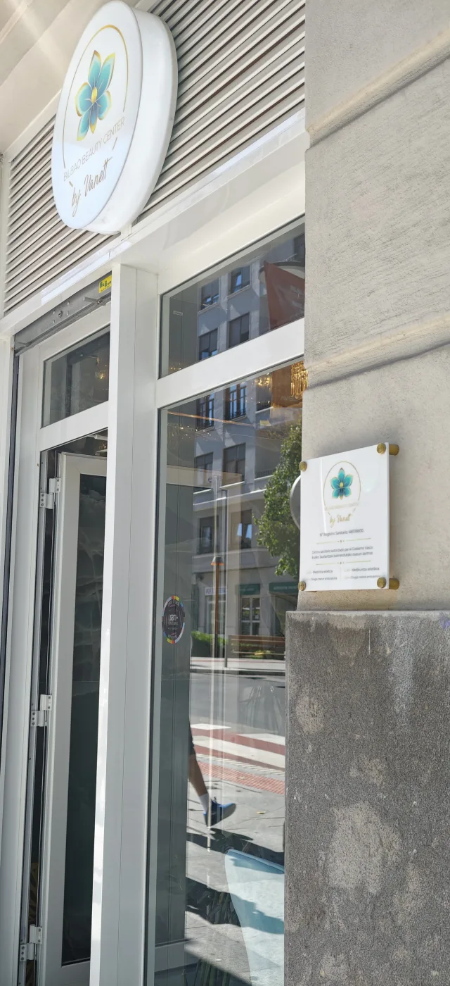 Entrada de Bilbao Beauty Center con el rótulo y la placa sanitaria junto a la puerta
