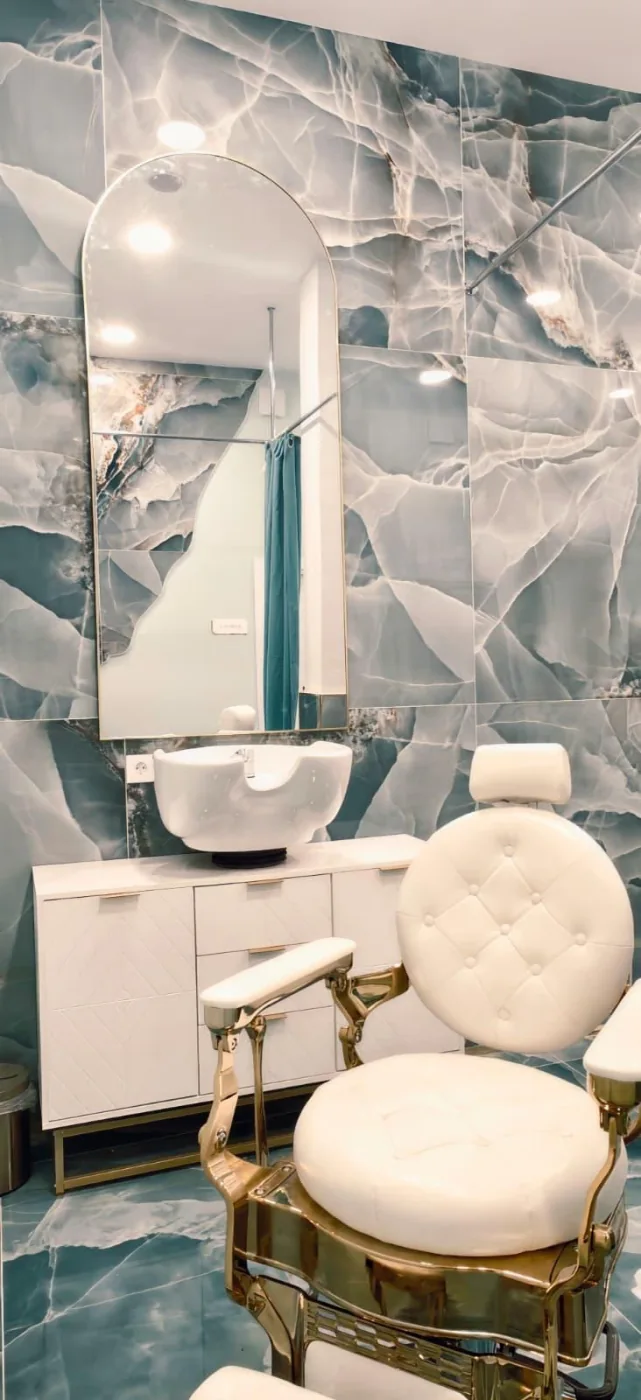 Zona de peluquería con espejo, sillón y lavacabezas