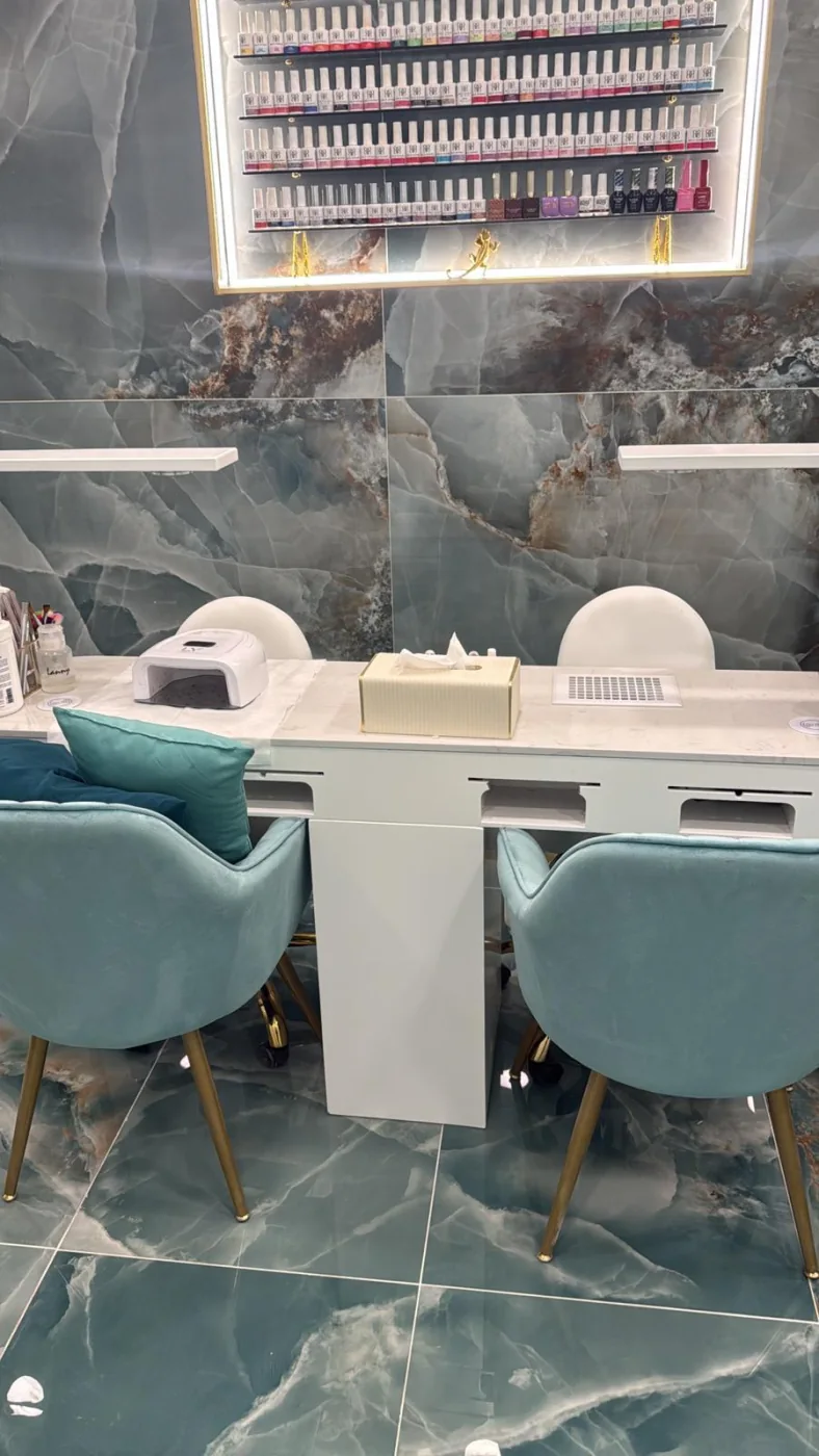 Mesas de manicura con sillas turquesas y expositor de esmaltes