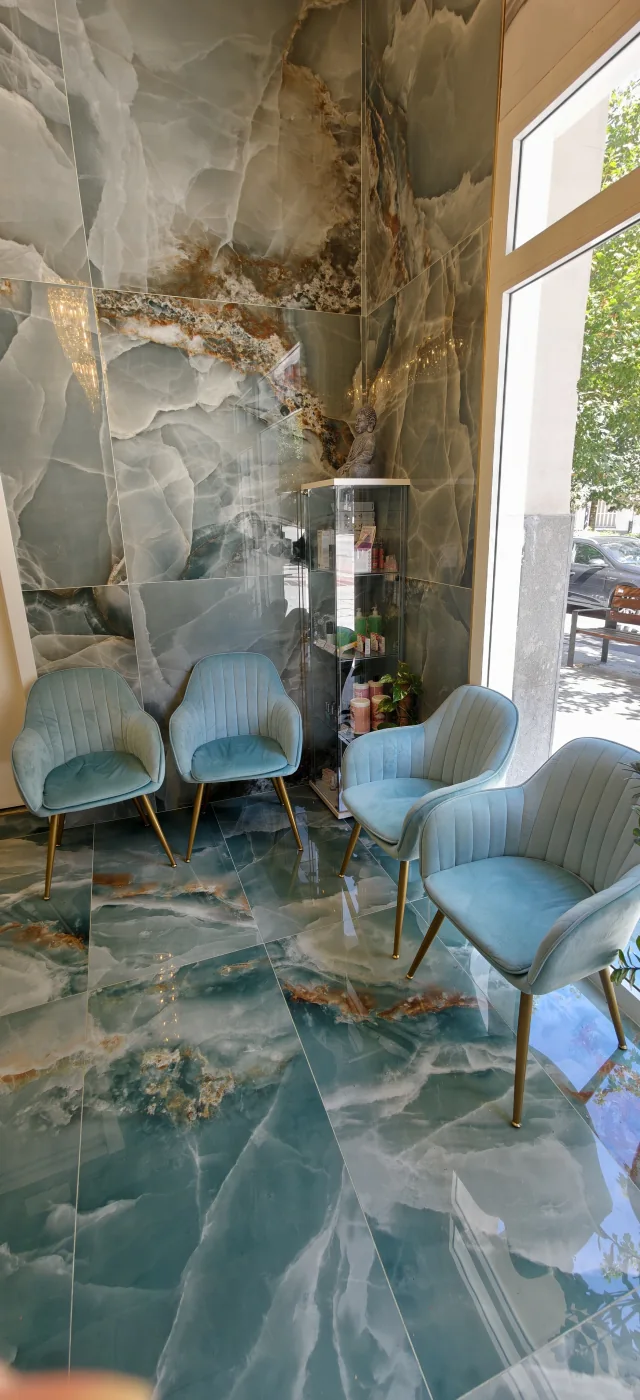Zona de espera junto al escaparate, con dos butacas turquesas